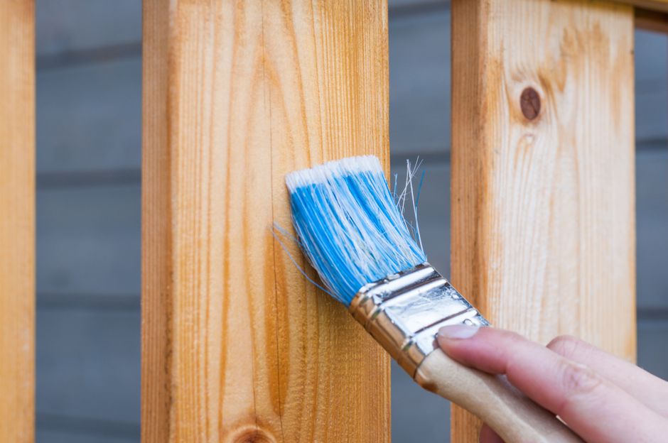 Hand painting a wooden board with a blue brush